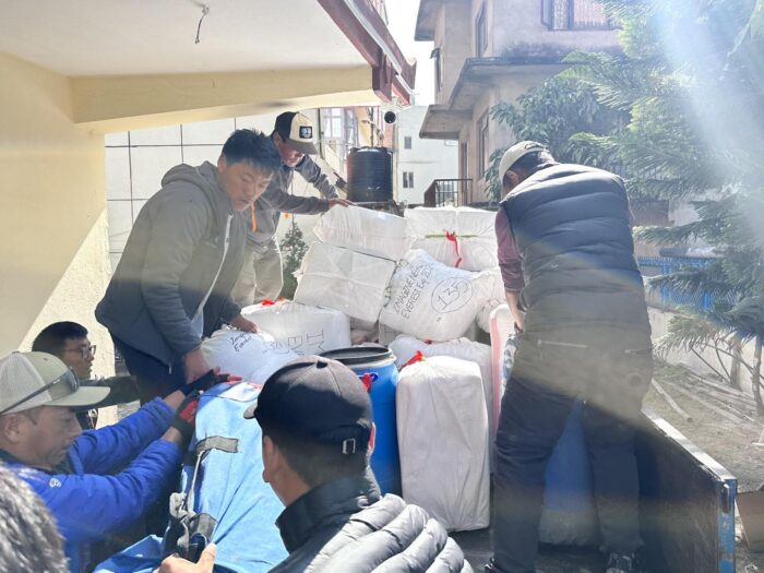 Sherpas loading bags on a truck.