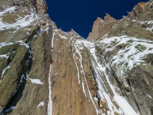 A climber on a thin, vertical ice line.