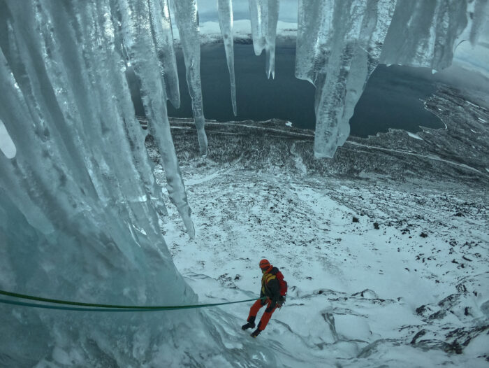 a climber rappels with icicles on top of the route.