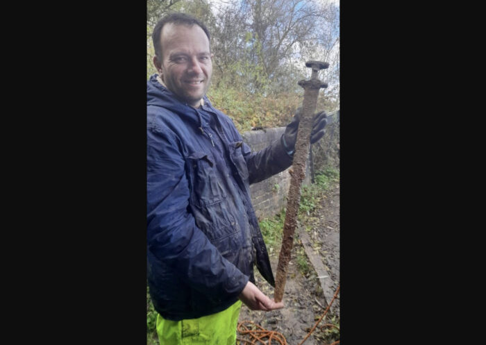 man holding a rusty sword