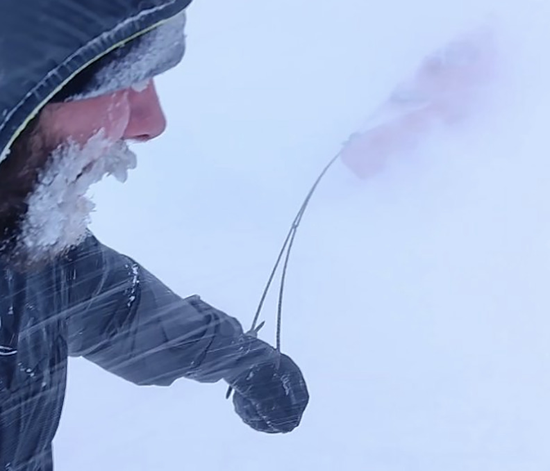 hauling a red kayak through a whiteout
