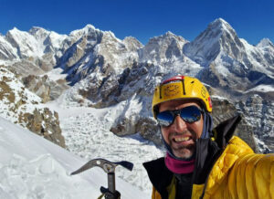 The climber with a background of snow peaks and an ice-axe in hand.