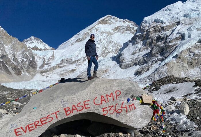 A treker on top of the stone at Everest Base Camp on the Khumbu Glacier.