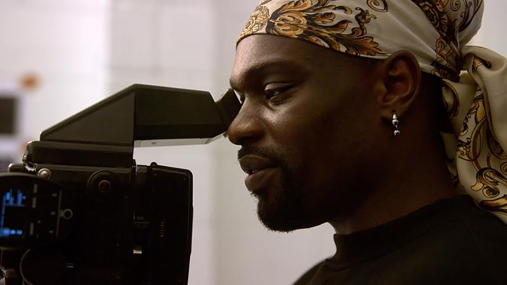 a man looking into the viewfinder of a video camera