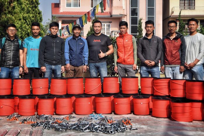 Sherpas pose with rolls of red rope.