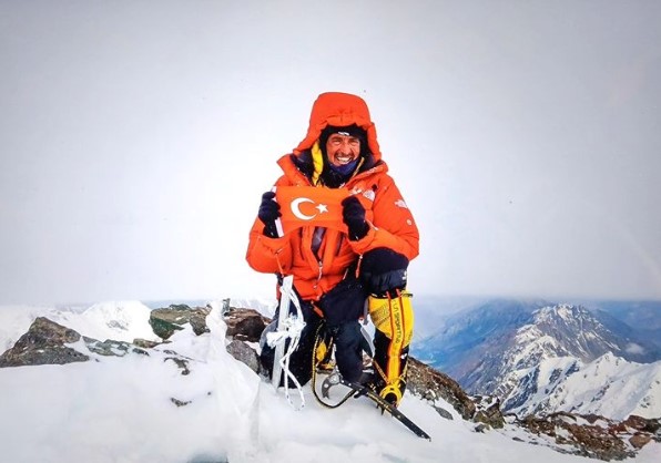 The climber with a Turkey's flag on a summit in a foggy day. 