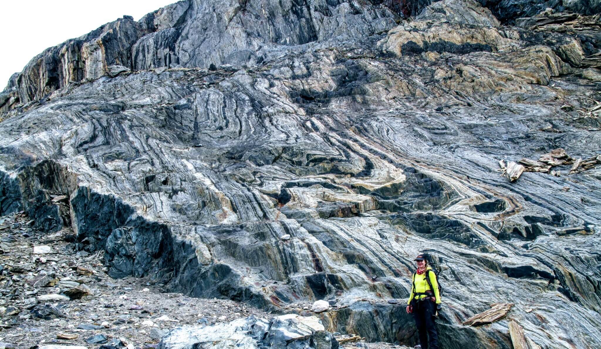 woman standing in front of swirled rock formation