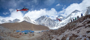 Two helicopters fly toward Everest Base Camp.