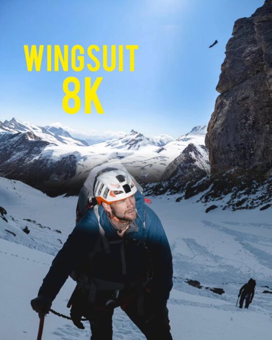 Howell leaning on an ice-axe, with backpack and climbing helmet.