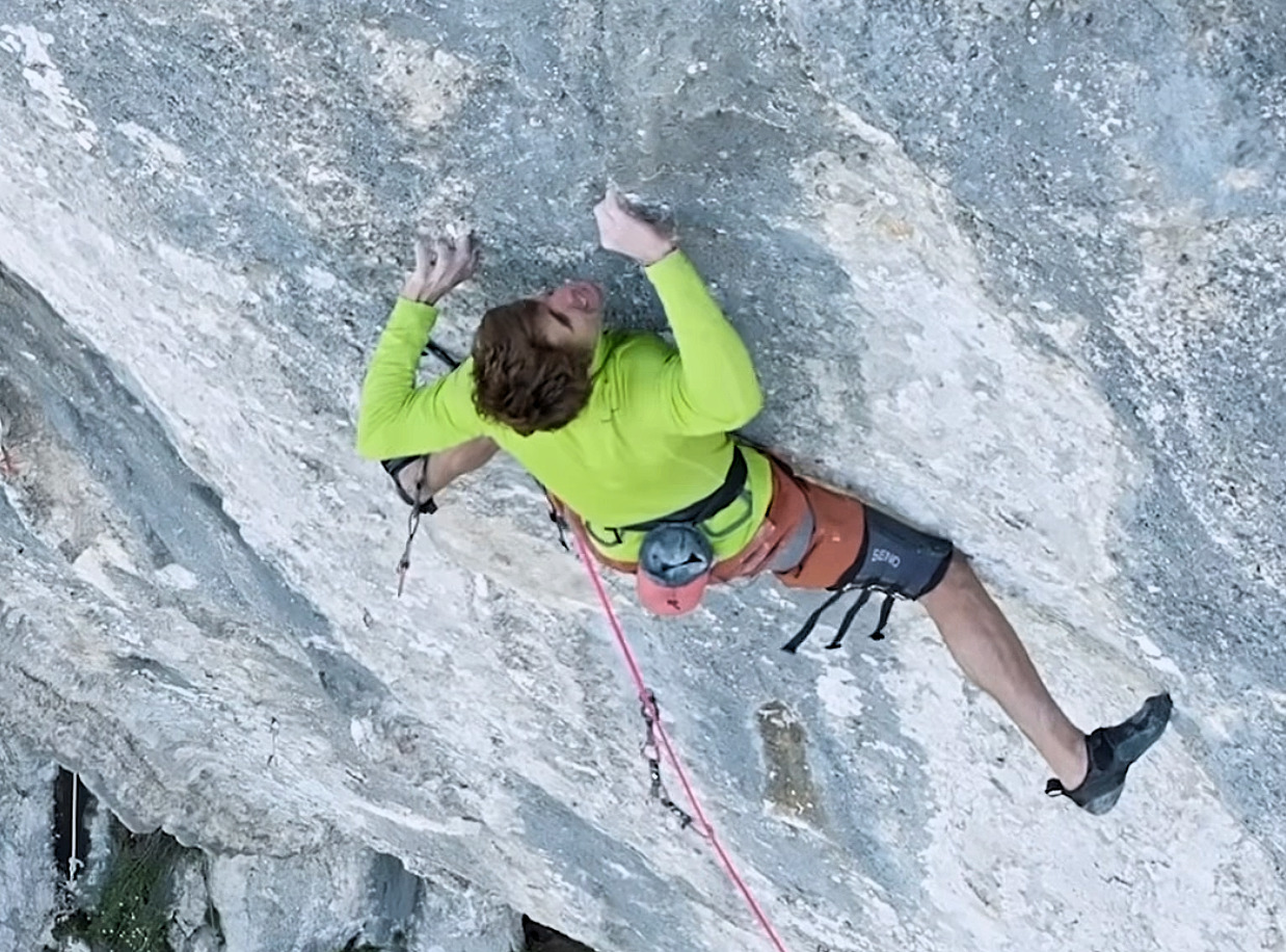climber on a step, colorful limestone wall