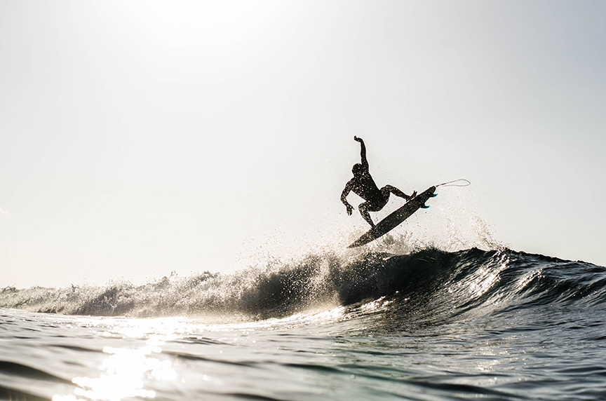 BW photo of surfer in the air off a wave