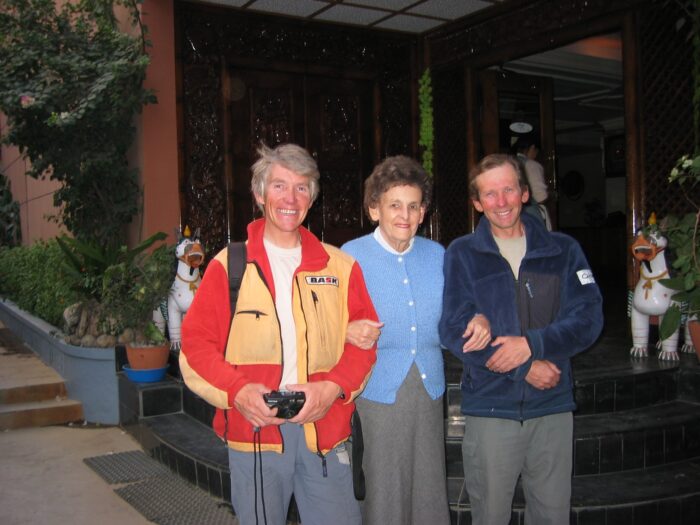 The climbers surrounding Miss Hawley in a hotel lobby .