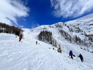 People with shovels at a snow slope.