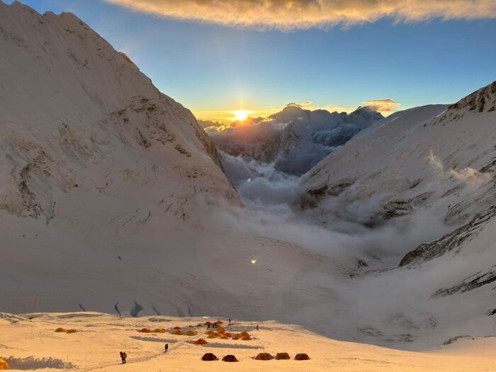 Tents in Camp 3 lit by the early morning sun, on the snowy Lhotse face, the Western Cwn wrapped in clouds below.
