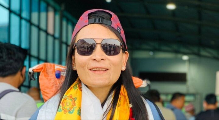 Phunjo Lama at an airport, with sunglasses and a cap