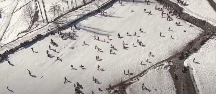 a wide, birds eye view shot of children skiing and snowboarding