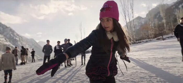a young girl rides a snowboard