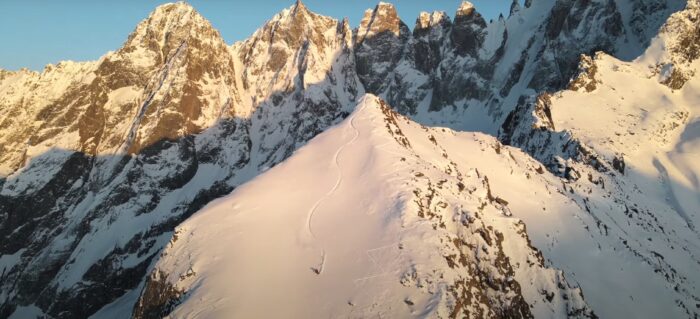 a wide shot of someone skiing down a mountain