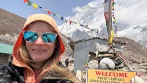 Allie Pepper poses in front of the board at Makalu Base Camp