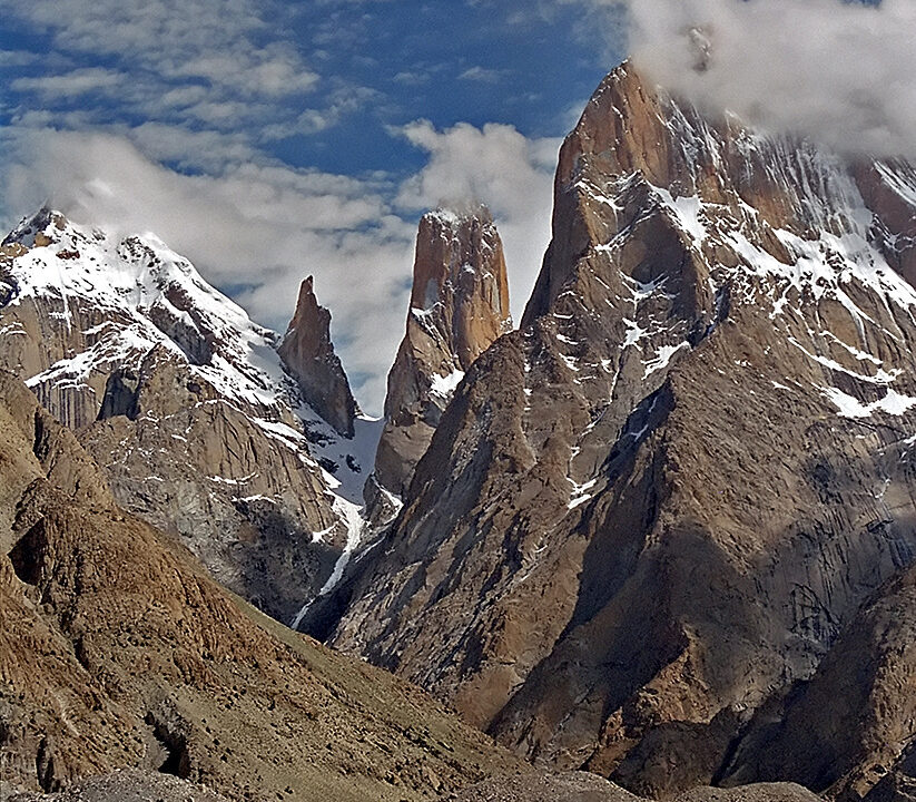 The Trango Towers partially capped by clouds