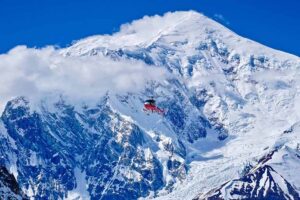 red rescue helicopter against white-blue peak