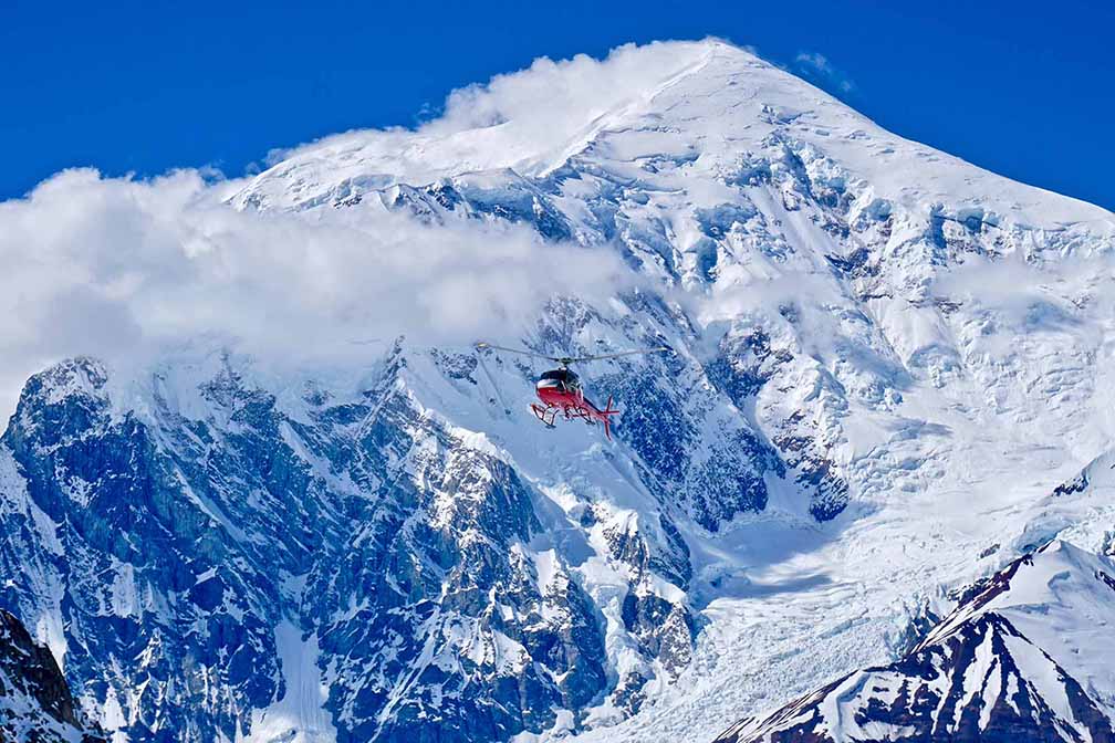 red rescue helicopter against white-blue peak