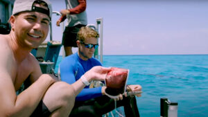 a man on a boat holds up a bag of blood