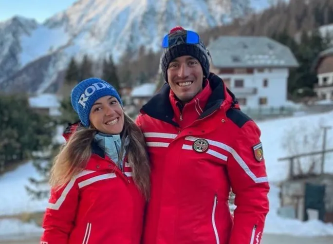 two red-jacketed skiers in the mountains