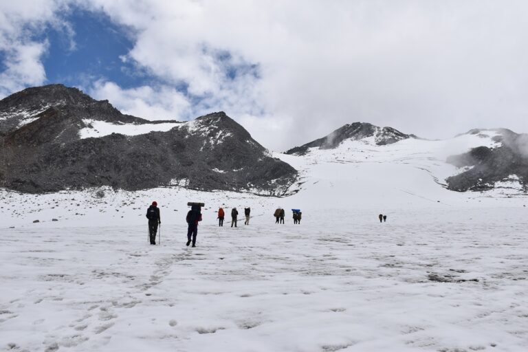 Trekkers heading for a wide snowy col