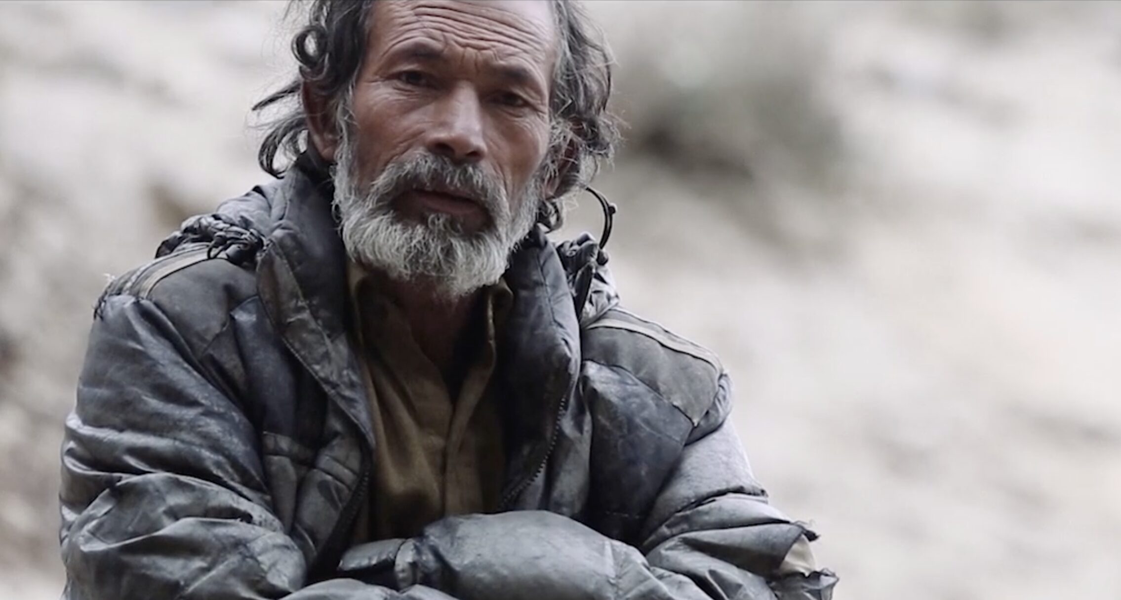 pakistani man with arms crossed in jacket