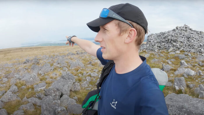 a man stands on a mountain and points