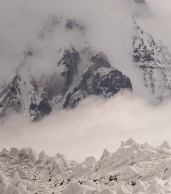 the lower part of K2 and the glacier below wrapped in clouds.