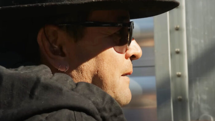 a man stares through a fence