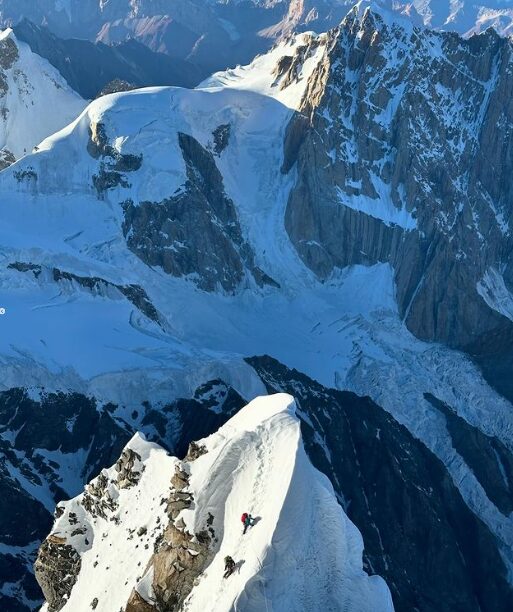Aerial picture of the climbers on the snowy, steep summit ridge.