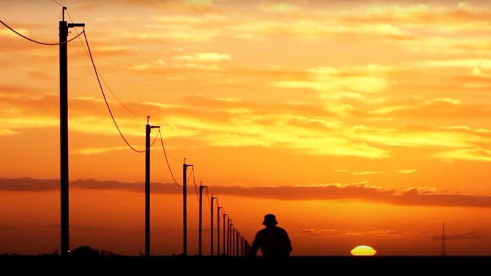 a man rides his bike down a road at sunset