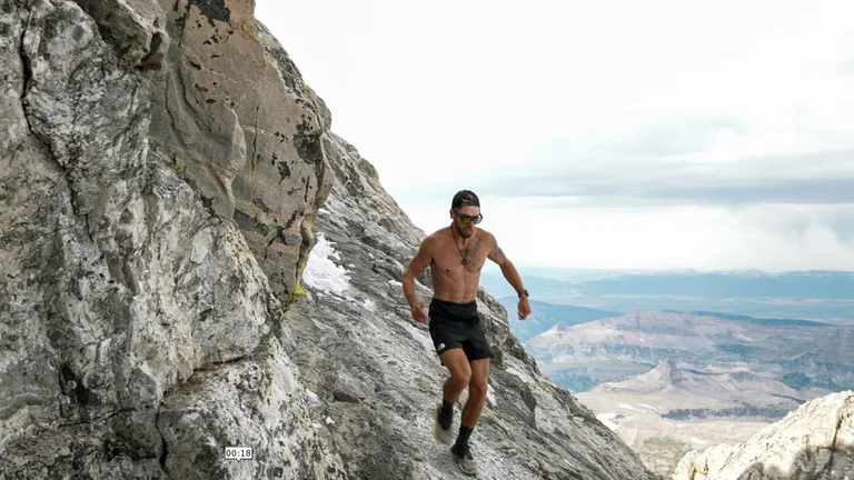 A man runs down a steep section of rock.