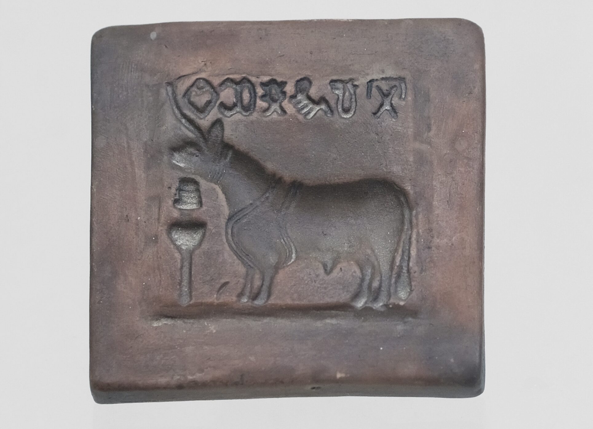 A tablet with sigils and a bull