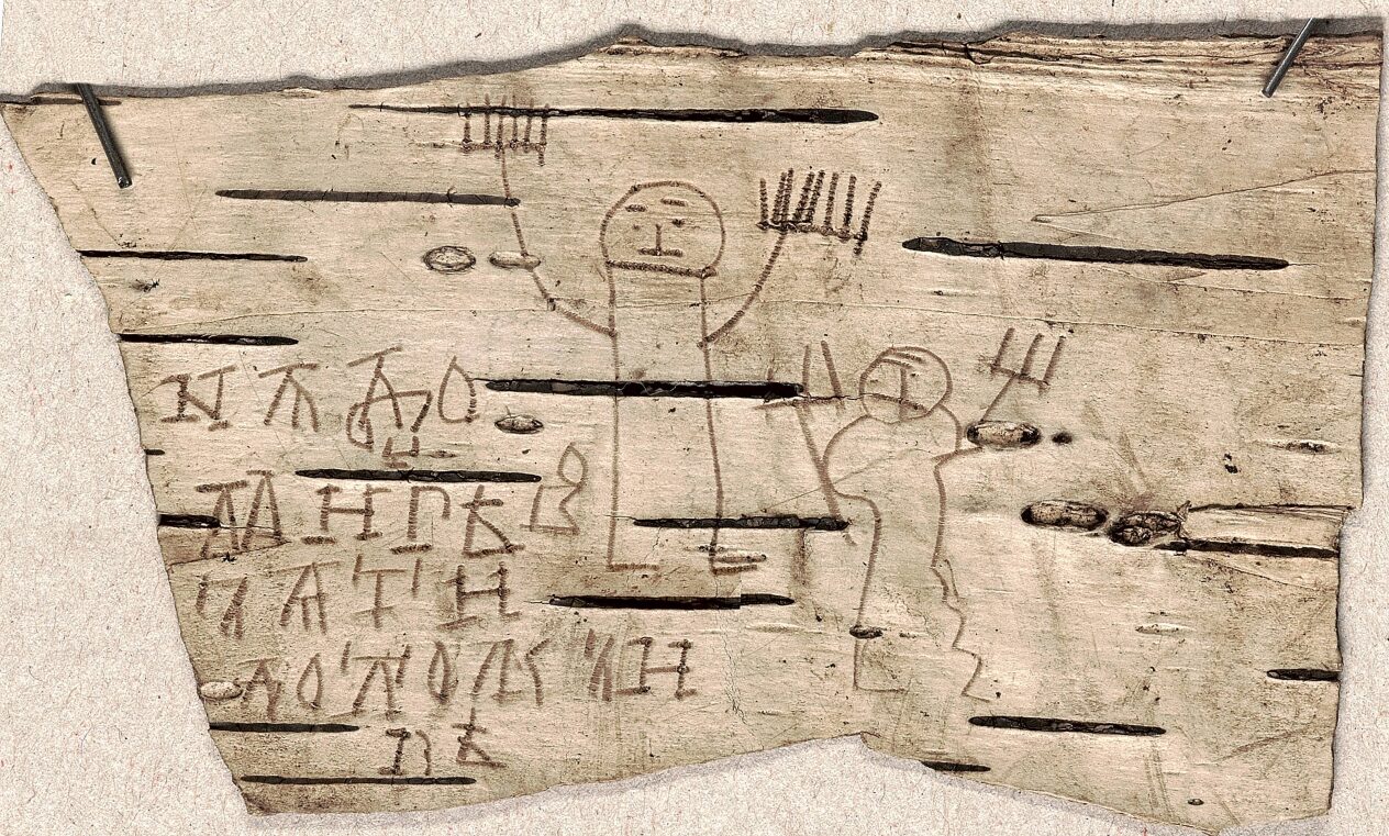 A child's drawing of two human figures beside text in Old Novgorod, written on birch bark.
