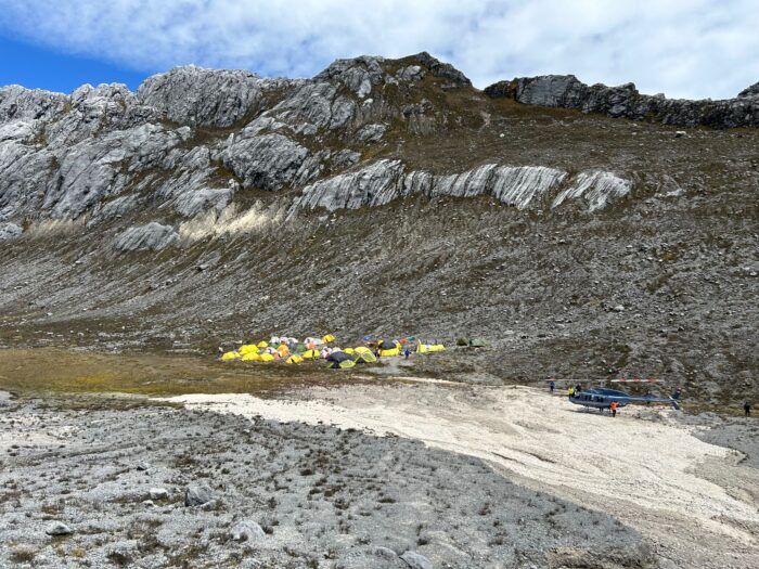 tents grouped below some rocky outcrops