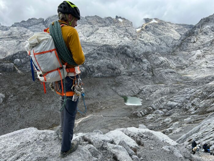 A Climber sstands on rocky terrain on Carstensz Pyramid