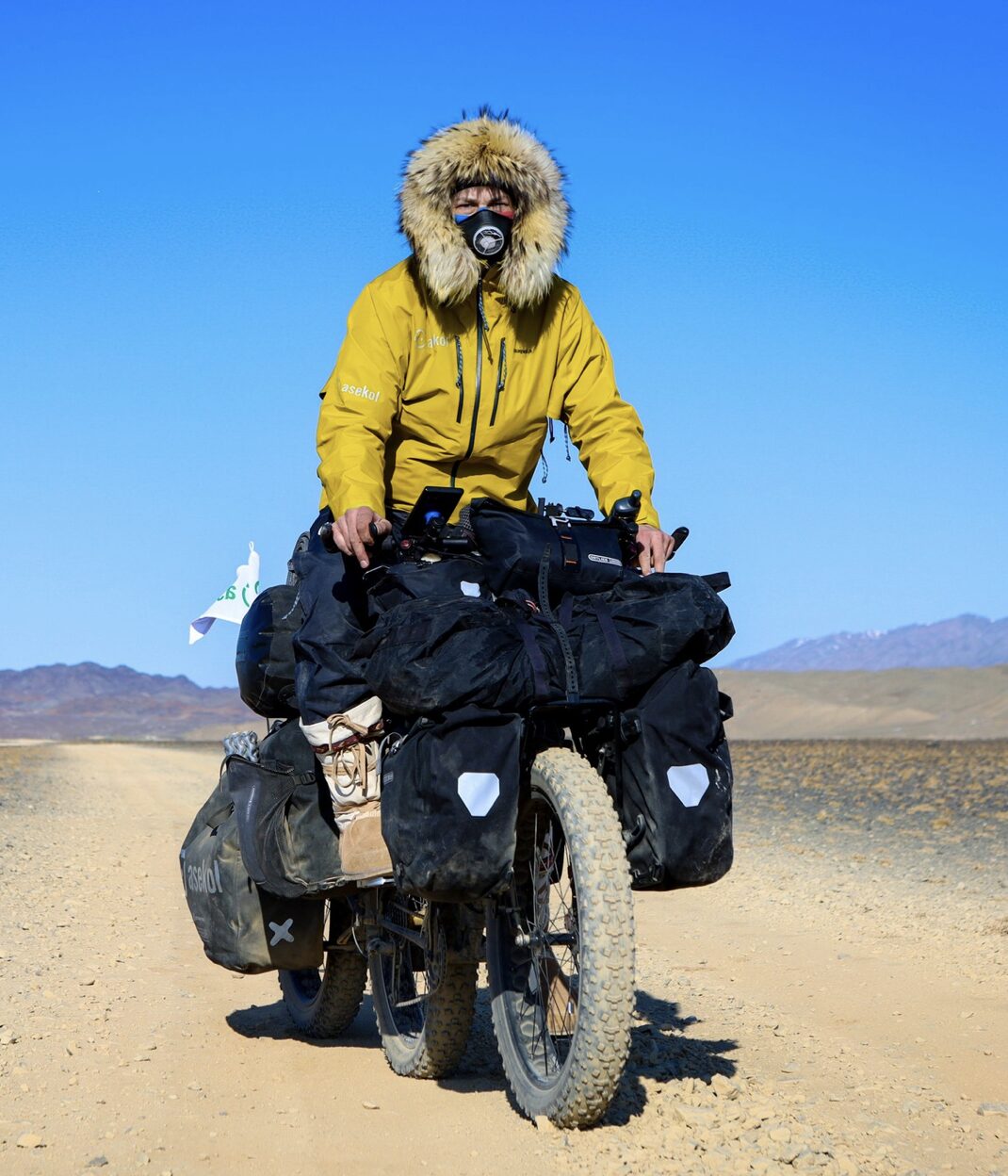 Mateusz Waligora with a heavy bike in the Gobi.