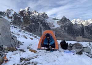 climber on snow in small tent