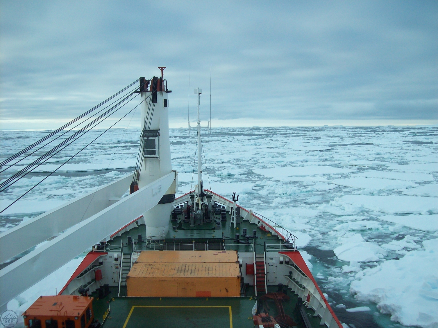 The bow of a ship, with an ice covered sea before it.