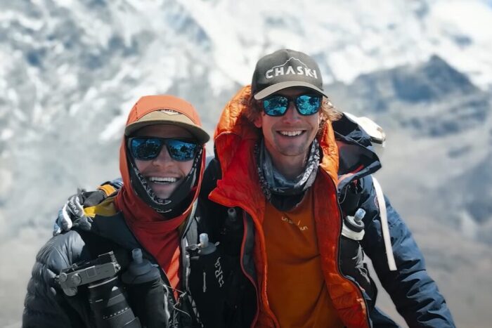 CLose shot of Fisher and Andrews smiling with a mountain behind.