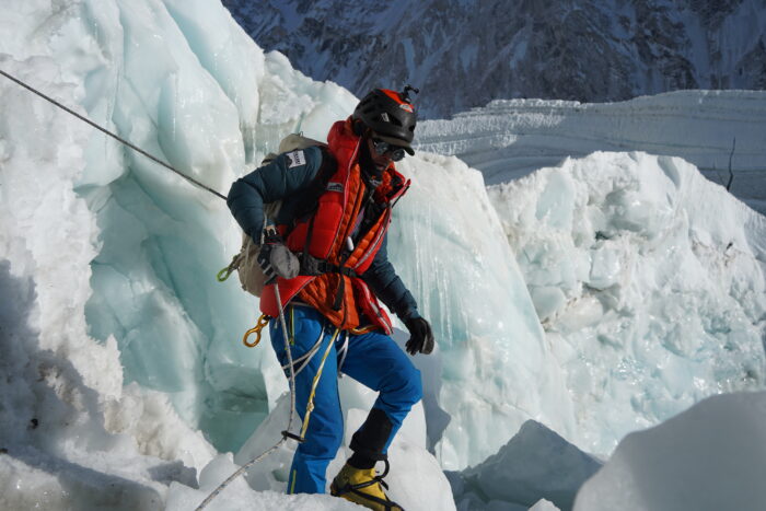 Andrews among blocks of ice at the Khumbu Icefall, holding a fixed rope.