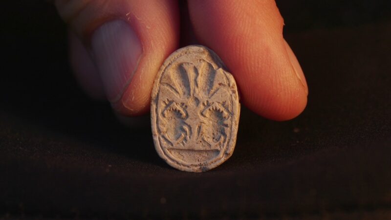 closeup photo of artifact between two fingers