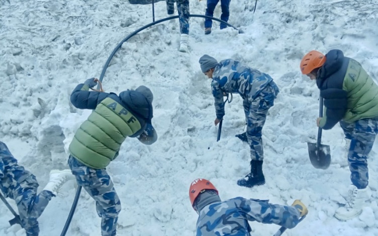 Rescuers digging the snow searching for body.