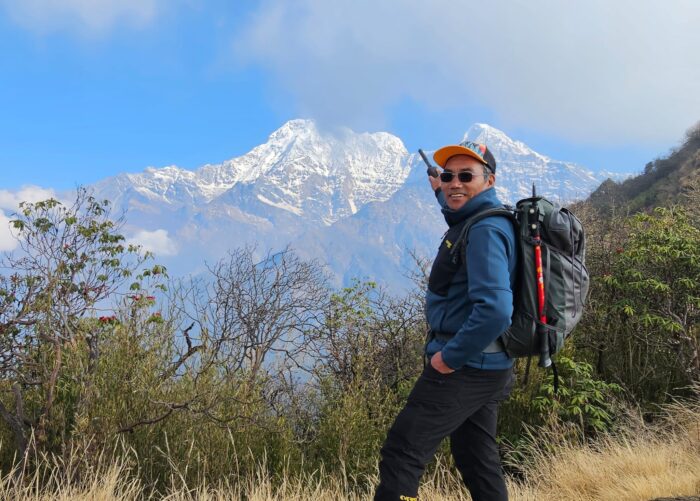 Kami Rita Sherpa points to the Himalayan peaks in the distance.