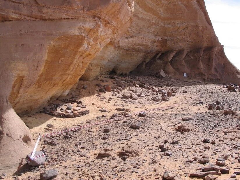 A sandy cliff, taped off, with visible evidence of ancient human activity.