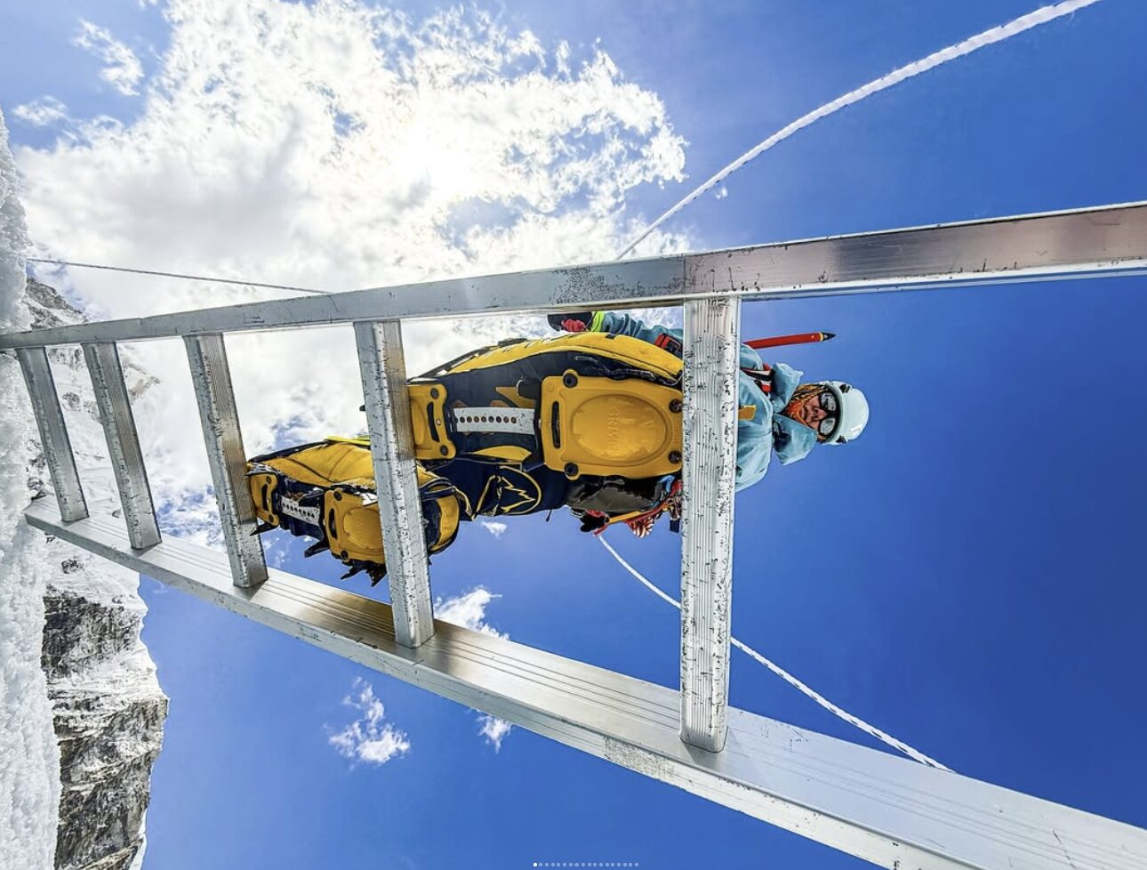 A climber cross a ladder over a crevasse on Everest, as seen brom below